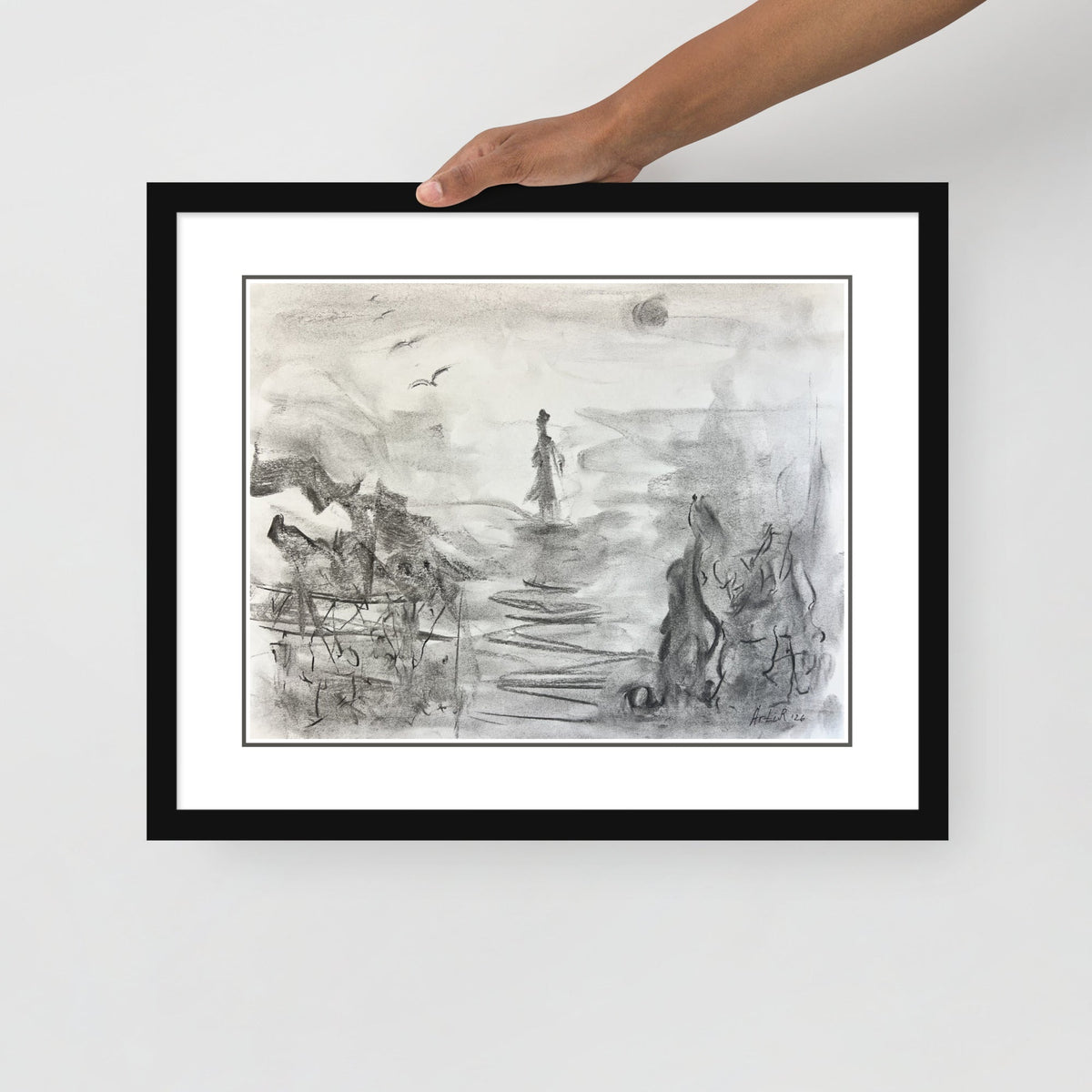 Hand holding the framed print — close-up
